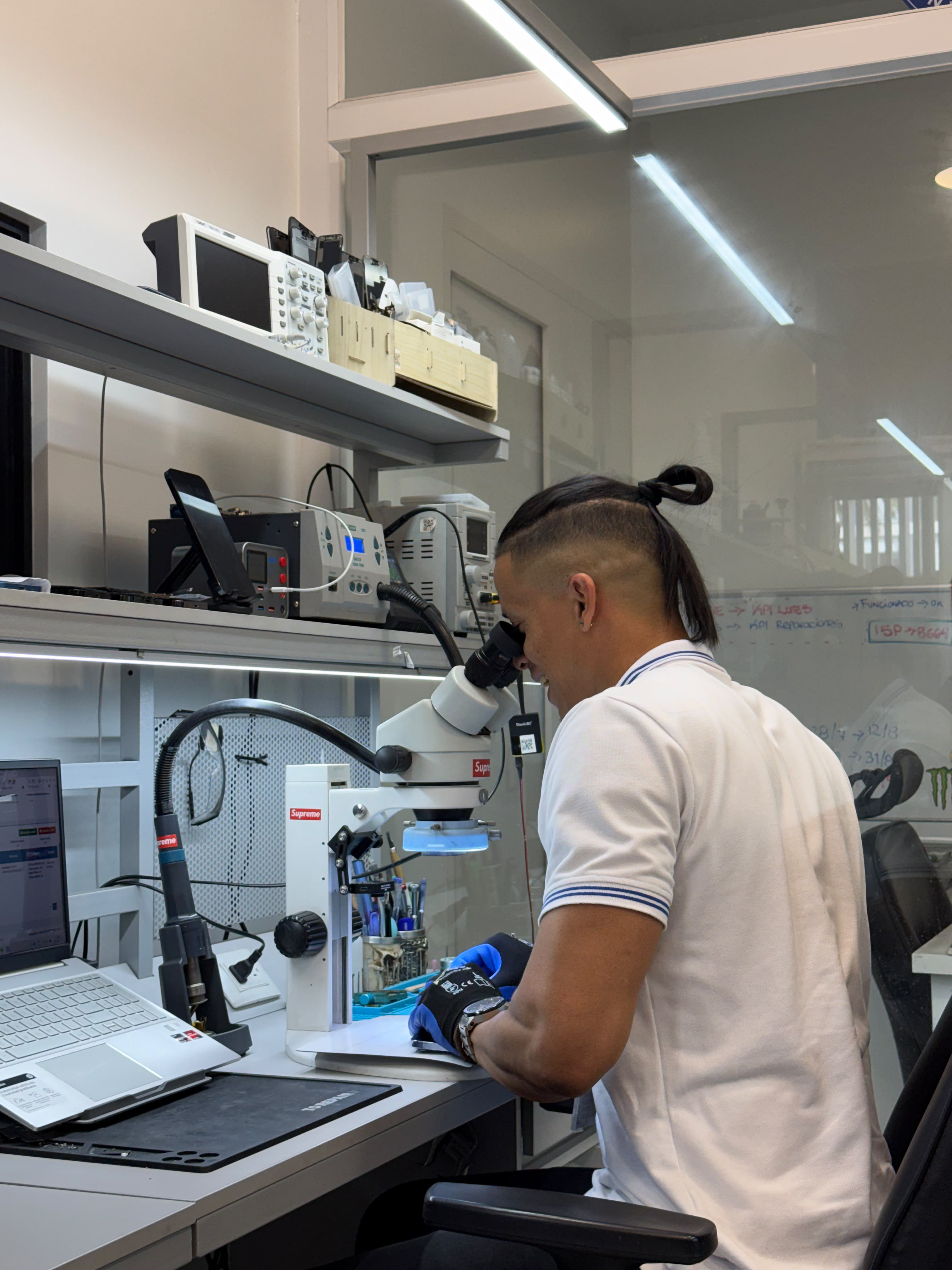 Técnico SmartFix trabajando con microscopio en la estación de microsoldadura